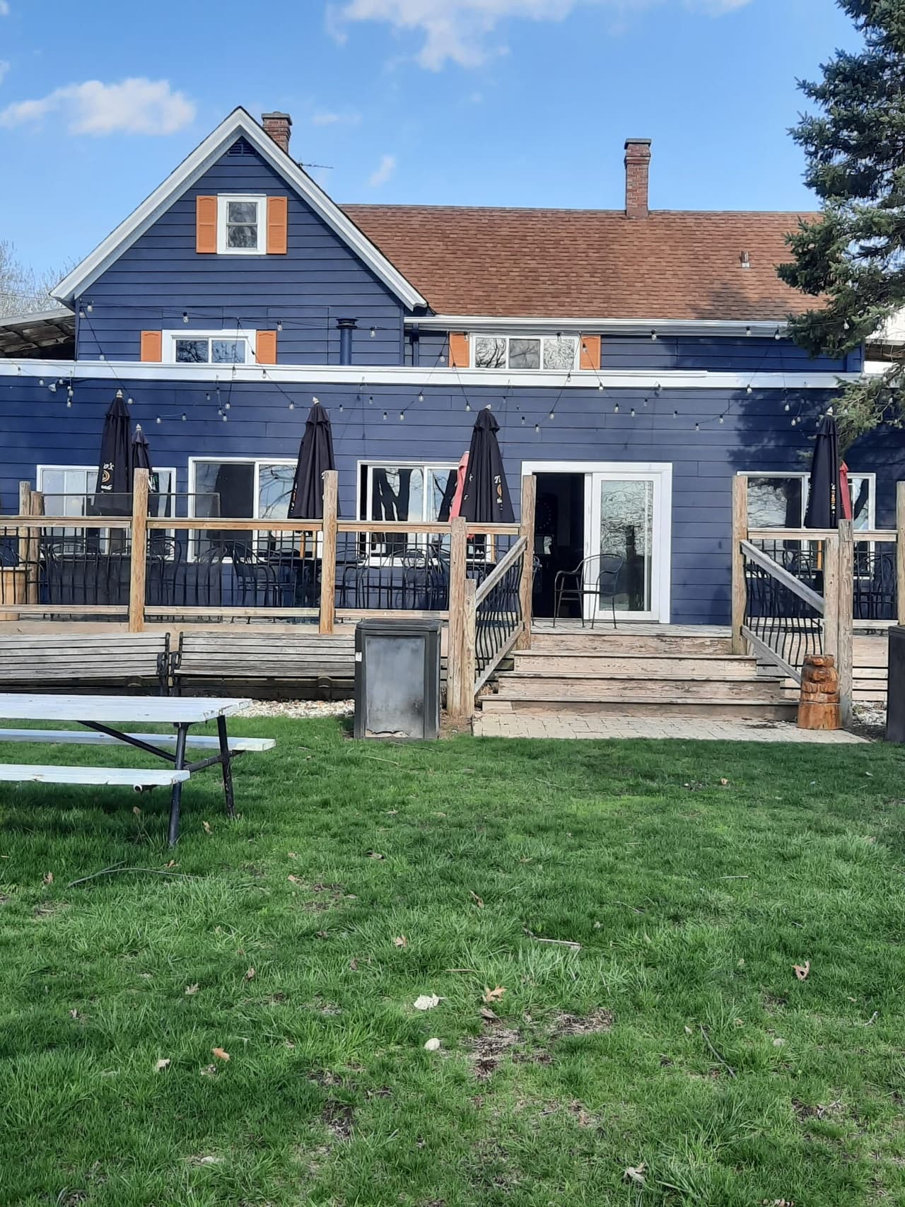 The navy-blue main building and deck from the lawn